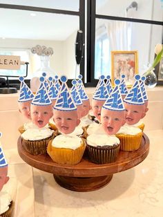 a group of cupcakes with blue hats on them sitting on top of a table