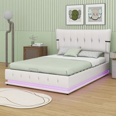 a white bed sitting in a bedroom on top of a hard wood floor next to a green wall