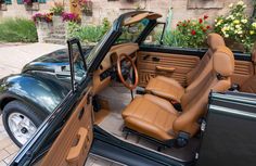 the interior of a car with brown leather seats and flowers in the back seat area