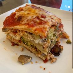 a close up of a plate of food with broccoli and lasagna