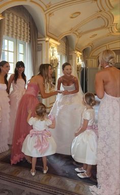 a group of women standing next to each other in front of a mirror on top of a floor