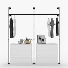 an open closet with clothes hanging on the rails and a potted plant next to it