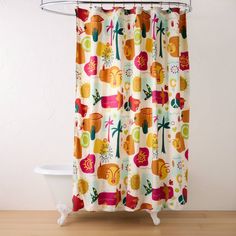 a shower curtain with colorful fruit and flowers on it in a white room next to a bathtub