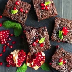 chocolate brownies with pomegranates and mint leaves on a slate board