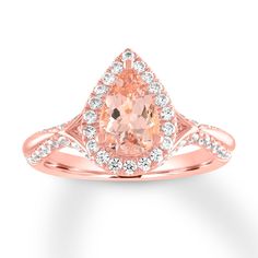 a pink diamond ring with white diamonds on the band and an oval cut stone in the center