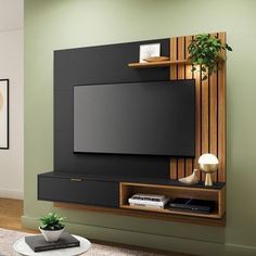 a living room with green walls and a black entertainment center on the wall, along with a potted plant