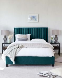 a bedroom with white walls and green headboard