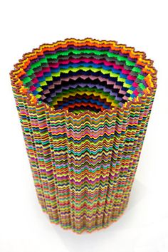 a stack of multicolored paper sitting on top of a white table next to each other