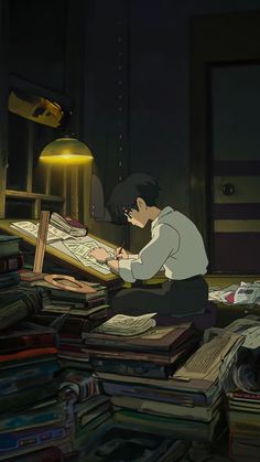 a man sitting on the floor in front of a pile of books with a lamp above him