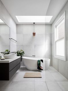 a white bath tub sitting under a bathroom window