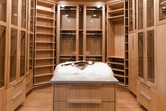 a large walk in closet with lots of wooden shelves and drawers on each side, filled with white fur