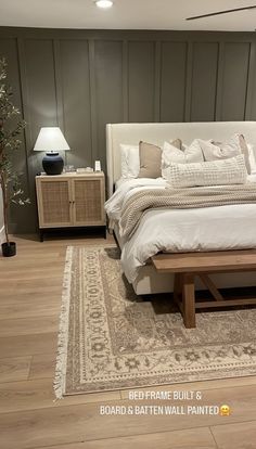 a large bed sitting on top of a hard wood floor next to a wooden table