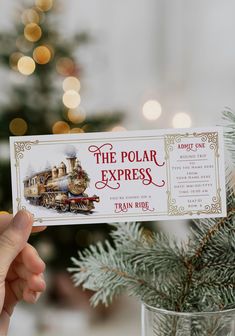 the polar express train ride ticket is being held up in front of a christmas tree