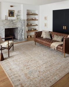 a living room filled with furniture and a fire place in the middle of the room