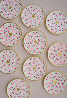 six decorated plates sitting on top of a table with confetti sprinkles