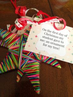 a christmas ornament made out of strips of paper with a card attached to it