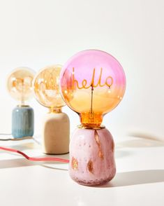 three glass globes with the word hello on them sitting next to each other,