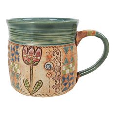 a ceramic mug with flowers painted on it