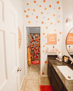 a bathroom with orange decorations on the wall and a sink in front of an open door