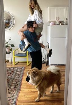 two people and a dog in a room