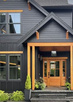 a large gray house with yellow trim and wooden front door is pictured in this image