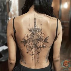 a woman's back with a cross tattoo on it