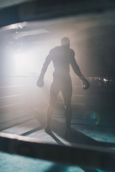 a man standing in front of a mirror holding a boxing glove