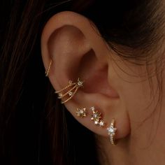 a woman's ear with three stars attached to the back of her ear,