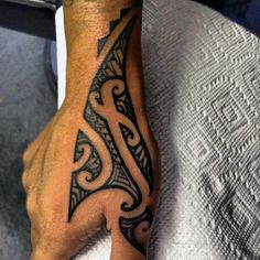 a man's hand with a tattoo design on the middle of his left arm