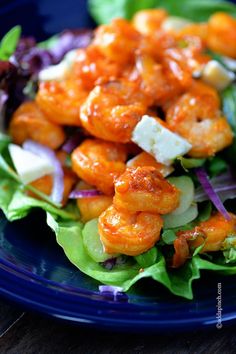 a blue plate topped with shrimp and lettuce