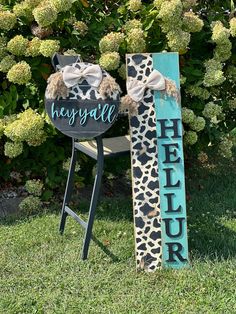 a wooden sign sitting in the grass next to a chair