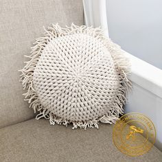 a white round pillow sitting on top of a couch