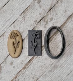 three metal objects sitting on top of a white wooden floor next to an oval rubber ring