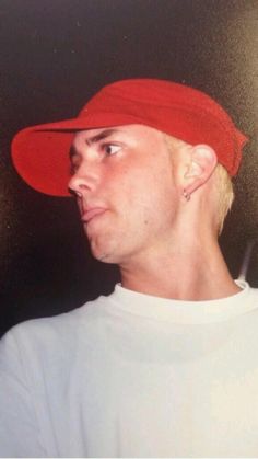 a young man wearing a red hat and looking off into the distance with his eyes wide open