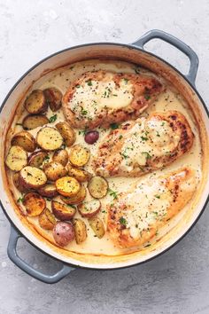 chicken with potatoes and gravy in a skillet on a white table top