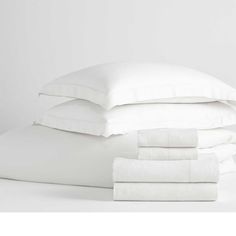 white sheets and pillows stacked on top of each other