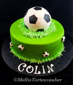 a green cake with a soccer ball on top and the words colin written in white