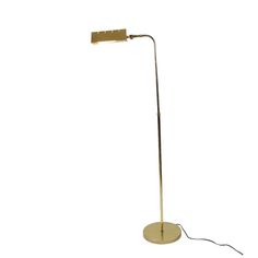 a floor lamp that is on top of a white surface and has a light plugged into it