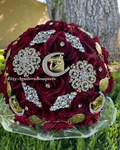 the bridal bouquet is made with red roses and brooches, surrounded by gold accents