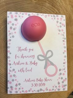 a pink ball and pair of scissors sitting on top of a card