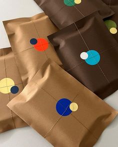 three brown bags with different colored circles on them