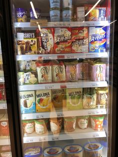 a refrigerator filled with lots of different types of drinks and snacks in it's glass doors