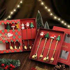 three christmas themed utensils in red boxes with gold spoons and santa clause on them