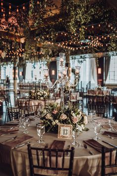 an elegant table set up for a wedding reception with candles and floral centerpieces