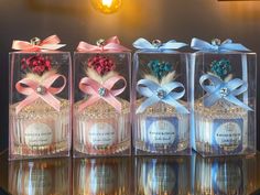 four small bottles with bows on them sitting on a table