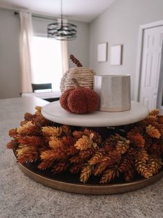 a coffee cup sitting on top of a table next to pine cones and other decorations