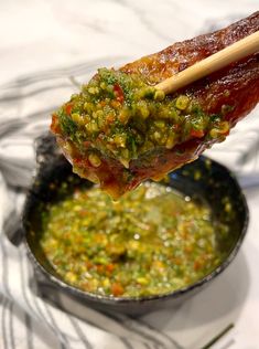 a spoon full of food on top of a bowl