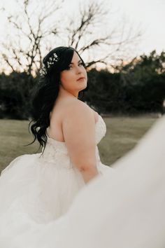 a woman in a wedding dress is standing outside