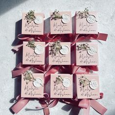 six wedding favors with pink ribbons and flowers on them are arranged in the shape of hearts