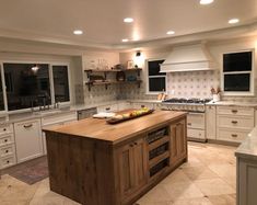 a large kitchen with an island in the middle and lots of cabinets on both sides